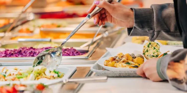 Woman helps herself to the buffet food on board a cruise ship. 