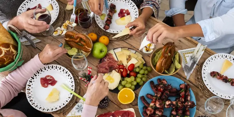 Group of travellers sitting around a table enjoying a selection of meze food. 