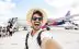 Happy tourist boarding on a plane at the airport - Handsome young man taking selfie picture in front of airplane - Summertime holidays and transportation life style concept