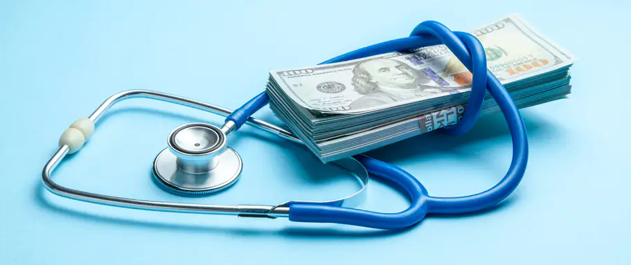 an image of stack of cash dollars and stethoscope on blue background. The concept of medical strechevka or expensive medicine, doctors salary